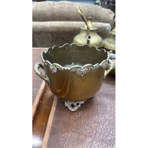 63 - Collection of six decorative brass items comprising four small footed kettles with wooden swing hand... 
