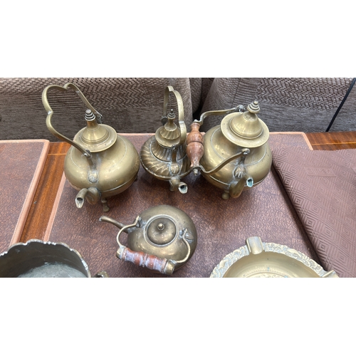 63 - Collection of six decorative brass items comprising four small footed kettles with wooden swing hand... 