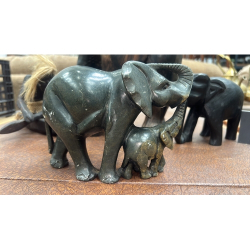 9 - Four African hand-carved ornaments: mottled green serpentine elephant with calf, grained hardwood el... 