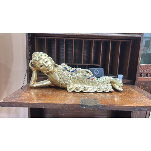 53 - Carved wooden figure of the reclining Buddha, gilt and embellished with coloured glass mosaic and ca... 