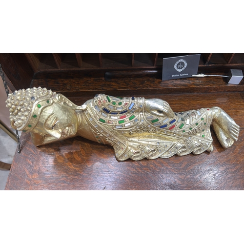53 - Carved wooden figure of the reclining Buddha, gilt and embellished with coloured glass mosaic and ca... 