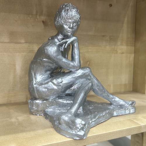 34 - Silver-painted plaster figure of a seated contemplative nude woman, legs crossed and chin resting on... 