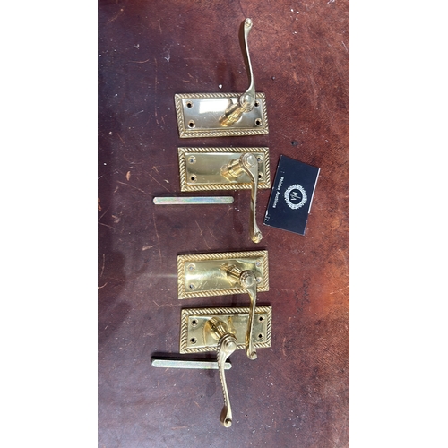 106 - Set of four polished brass lever door handles, each on rectangular rope-twist moulded backplate with... 