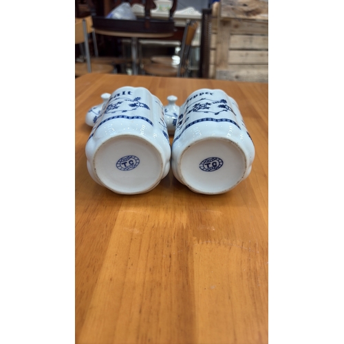 125 - Pair of cylindrical porcelain lidded salt and pepper pots, octagonal section, blue floral scroll dec... 