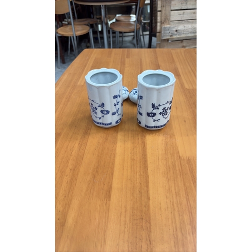 125 - Pair of cylindrical porcelain lidded salt and pepper pots, octagonal section, blue floral scroll dec... 