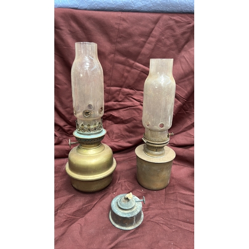 142 - Group of two brass kerosene oil lamps with pierced burners and clear glass chimneys, accompanied by ... 