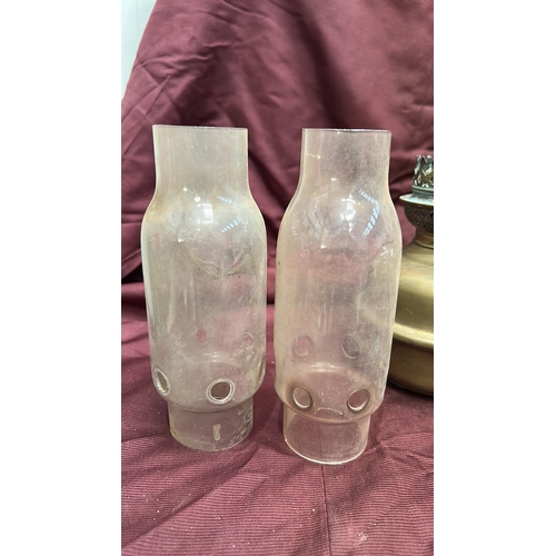 142 - Group of two brass kerosene oil lamps with pierced burners and clear glass chimneys, accompanied by ... 