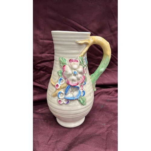 255 - Newport Pottery. Cream-glazed earthenware jug, ribbed body with polychrome moulded floral panels, br... 