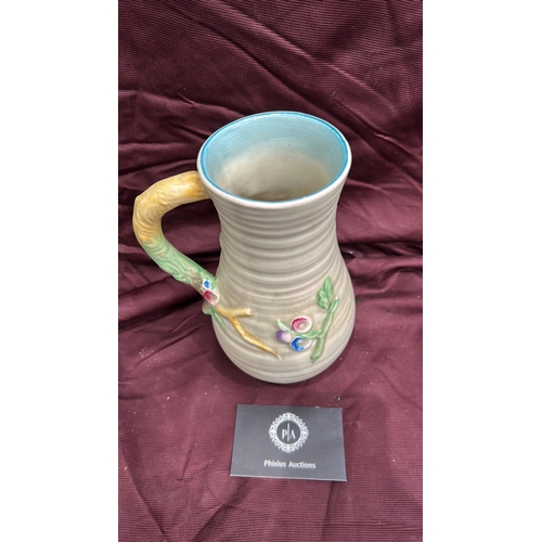 255 - Newport Pottery. Cream-glazed earthenware jug, ribbed body with polychrome moulded floral panels, br... 