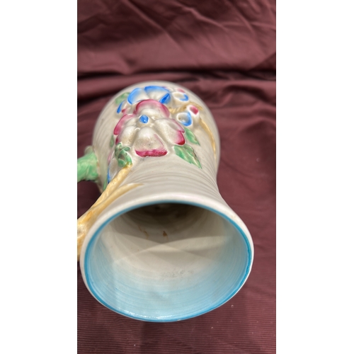 255 - Newport Pottery. Cream-glazed earthenware jug, ribbed body with polychrome moulded floral panels, br... 