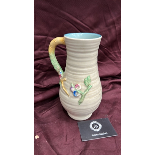 255 - Newport Pottery. Cream-glazed earthenware jug, ribbed body with polychrome moulded floral panels, br... 