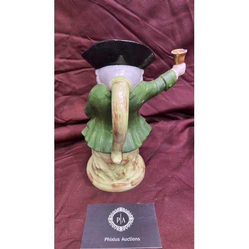 256 - Porcelain character toby jug modelled as a Town Crier with raised bell, tricorn hat forming rim, int... 