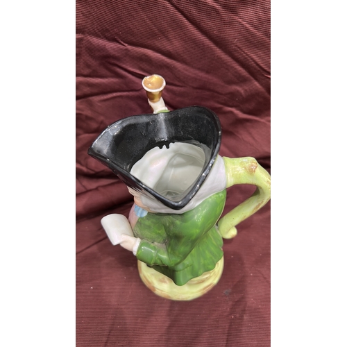 256 - Porcelain character toby jug modelled as a Town Crier with raised bell, tricorn hat forming rim, int... 