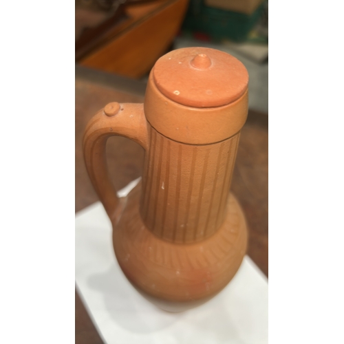 413 - Terracotta handled ewer with domed knop lid, incised vertical fluting to neck and geometric band to ... 