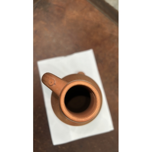 413 - Terracotta handled ewer with domed knop lid, incised vertical fluting to neck and geometric band to ... 