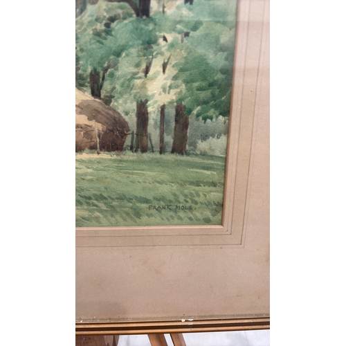 450 - Framed watercolour landscape depicting haystacks beneath mature trees, signed lower right “Frank Hol... 