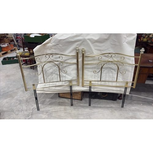 467 - Pair of tubular brass-finish single bed headboards, each with scrolled openwork panels and urn finia... 