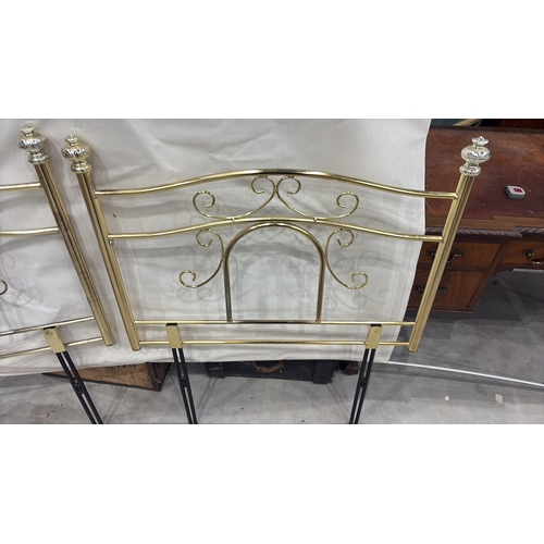 467 - Pair of tubular brass-finish single bed headboards, each with scrolled openwork panels and urn finia... 
