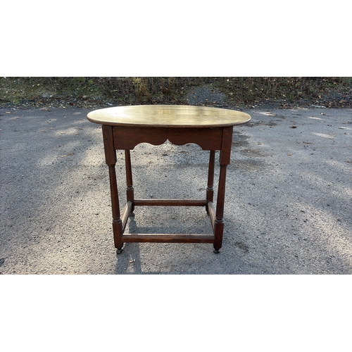 207 - Oval oak occasional table, early 20th century, plank top above scalloped frieze, turned legs united ... 