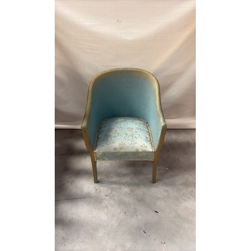 216 - Painted wicker tub chair with curved barrel back, gold-toned rim and floral upholstered seat.