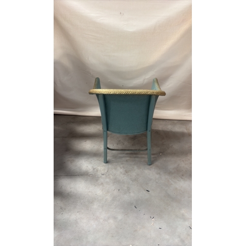 216 - Painted wicker tub chair with curved barrel back, gold-toned rim and floral upholstered seat.