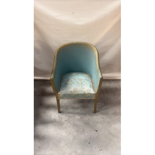 216 - Painted wicker tub chair with curved barrel back, gold-toned rim and floral upholstered seat.