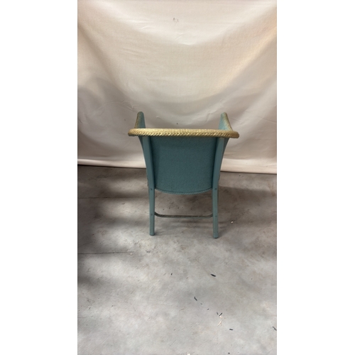 216 - Painted wicker tub chair with curved barrel back, gold-toned rim and floral upholstered seat.