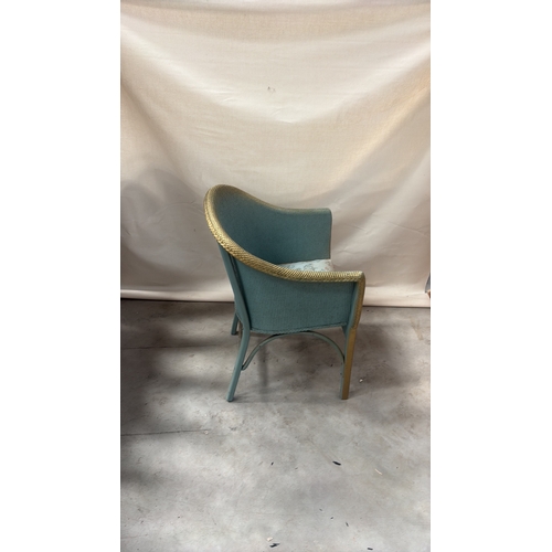 216 - Painted wicker tub chair with curved barrel back, gold-toned rim and floral upholstered seat.