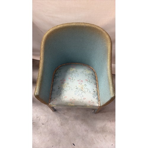 216 - Painted wicker tub chair with curved barrel back, gold-toned rim and floral upholstered seat.