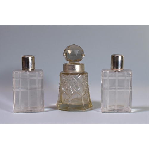 226 - A pair of Mappin & Webb silver topped scent bottles.London, 1946 engine turned tops. Together wi... 