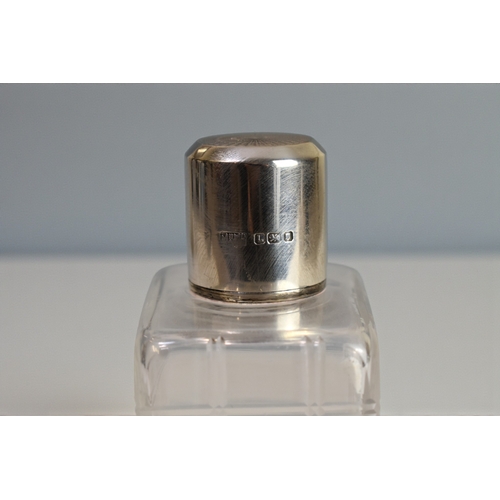 226 - A pair of Mappin & Webb silver topped scent bottles.London, 1946 engine turned tops. Together wi... 