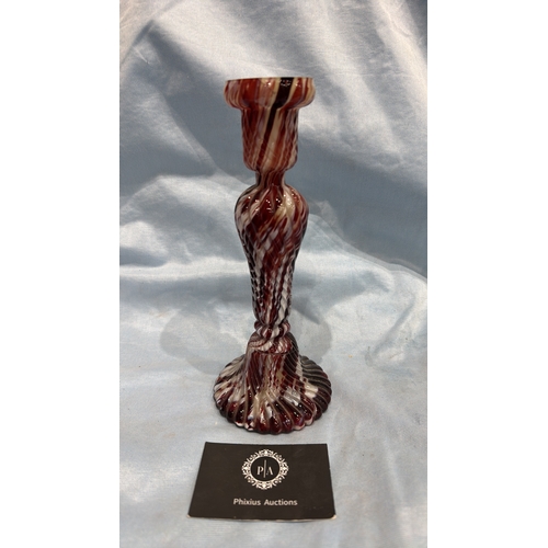 114 - Spiral-moulded candlestick of marbled red, white and cream art glass, the fluted stem rising from a ... 