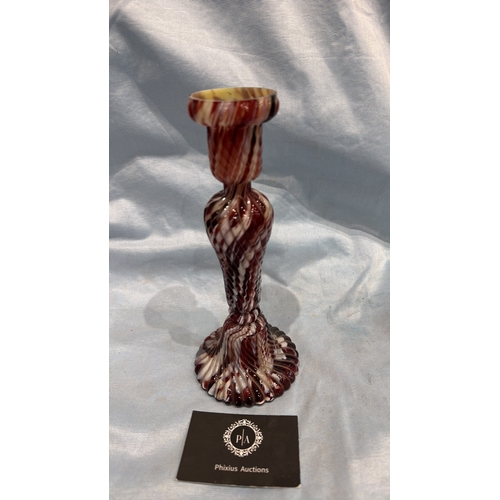 114 - Spiral-moulded candlestick of marbled red, white and cream art glass, the fluted stem rising from a ... 