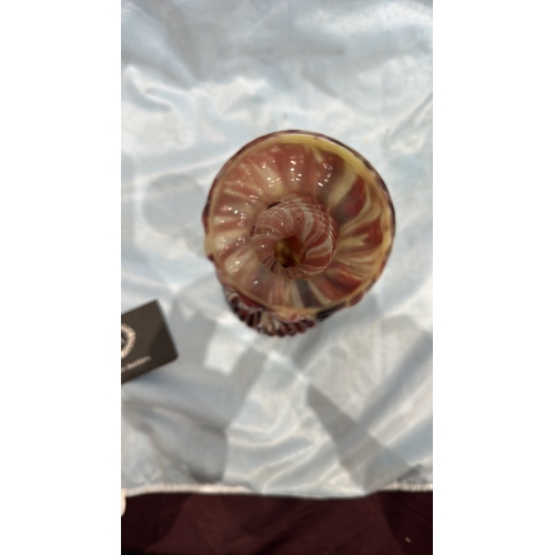 114 - Spiral-moulded candlestick of marbled red, white and cream art glass, the fluted stem rising from a ... 