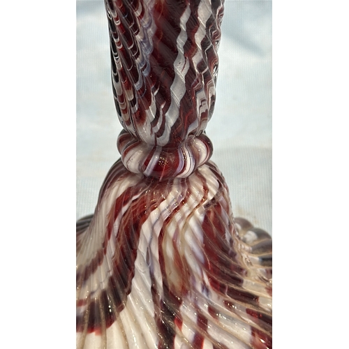 114 - Spiral-moulded candlestick of marbled red, white and cream art glass, the fluted stem rising from a ... 