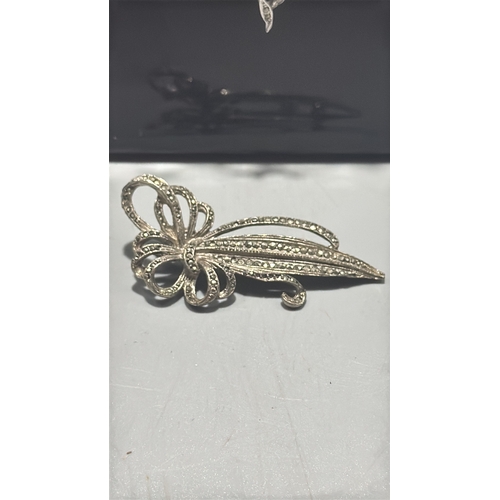 128 - Two silver tone marcasite jewellery items comprising a delicate chain necklace with scrolling ribbon... 