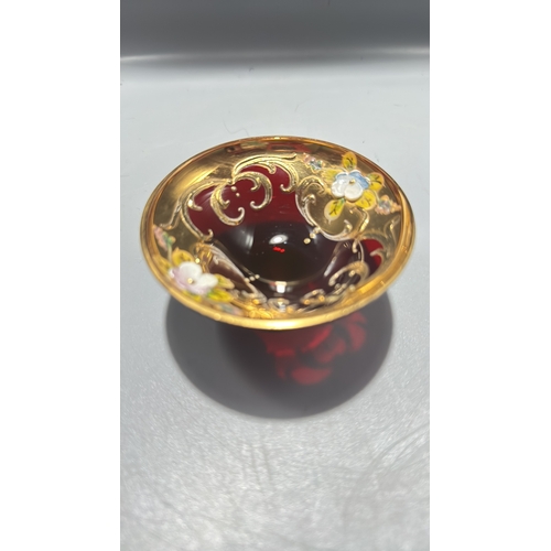 136 - Ruby red Italian glass miniature pedestal bowl, richly gilt with scrollwork and applied polychrome e... 