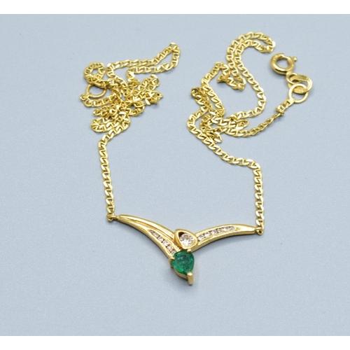 244 - 18ct gold ladies Diamond and Emerald cross over pendant necklace the pendant measures 30mm across by... 