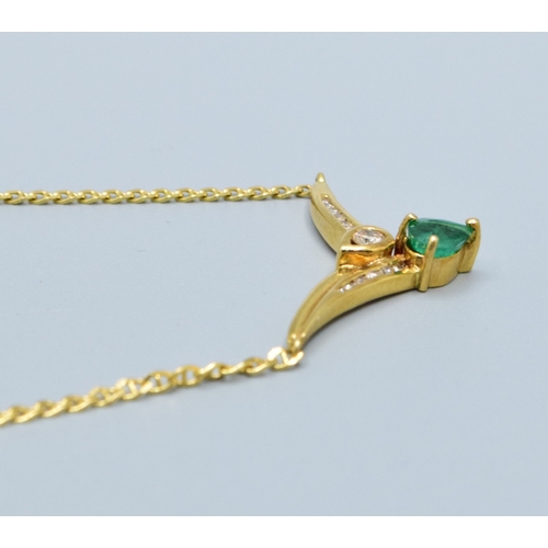 244 - 18ct gold ladies Diamond and Emerald cross over pendant necklace the pendant measures 30mm across by... 