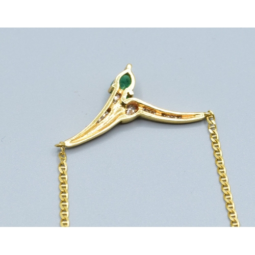 244 - 18ct gold ladies Diamond and Emerald cross over pendant necklace the pendant measures 30mm across by... 