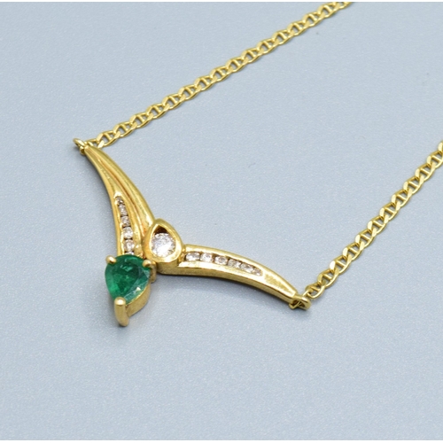 244 - 18ct gold ladies Diamond and Emerald cross over pendant necklace the pendant measures 30mm across by... 