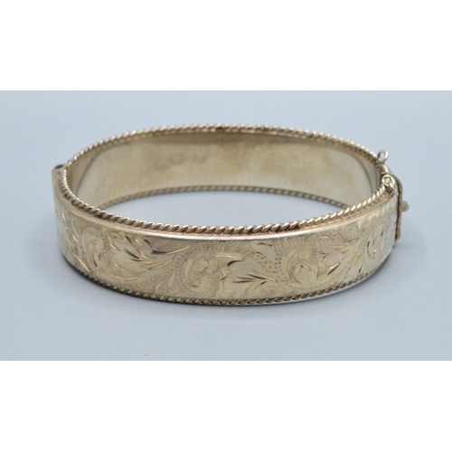 30 - 925 silver ladies embossed design bangle having 6cm internal diameter, and being 1.5cm tall both sid... 