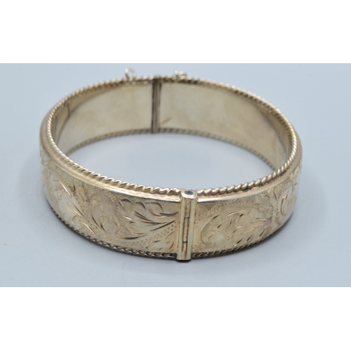 30 - 925 silver ladies embossed design bangle having 6cm internal diameter, and being 1.5cm tall both sid... 