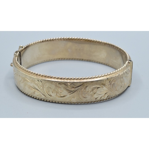30 - 925 silver ladies embossed design bangle having 6cm internal diameter, and being 1.5cm tall both sid... 