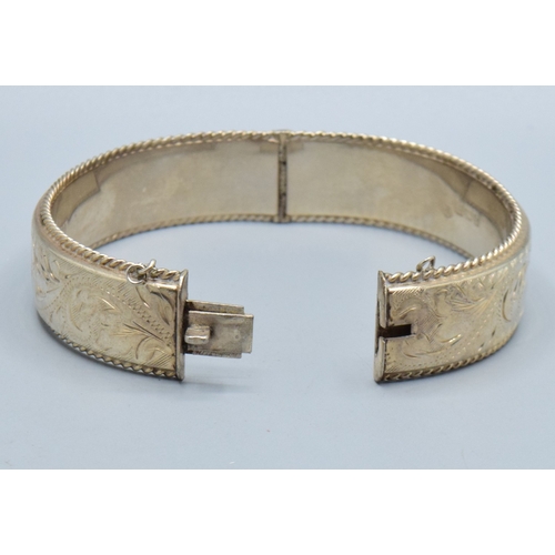 30 - 925 silver ladies embossed design bangle having 6cm internal diameter, and being 1.5cm tall both sid... 
