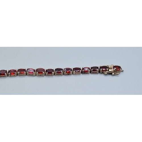 764 - Vintage sterling silver garnet line bracelet, together with a pair of art Deco drop paste earrings (... 