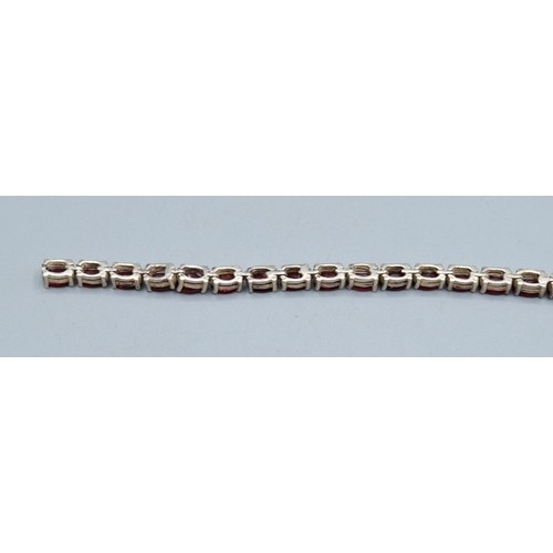 764 - Vintage sterling silver garnet line bracelet, together with a pair of art Deco drop paste earrings (... 