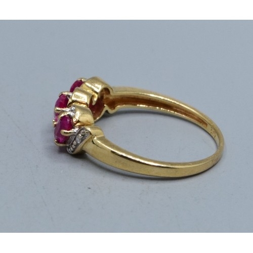 552 - 9ct gold ladies triple Ruby and Diamond gem set halo twist ring hallmarked as Diamond size N,