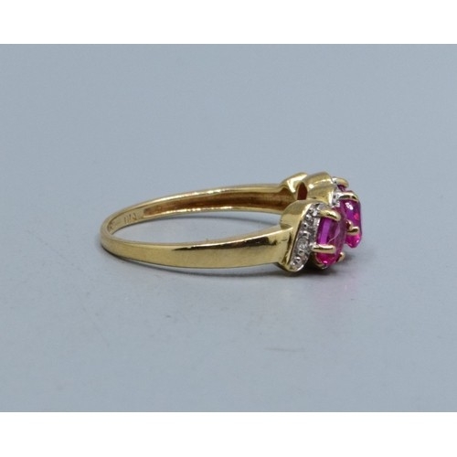 552 - 9ct gold ladies triple Ruby and Diamond gem set halo twist ring hallmarked as Diamond size N,