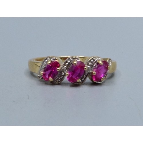 552 - 9ct gold ladies triple Ruby and Diamond gem set halo twist ring hallmarked as Diamond size N,